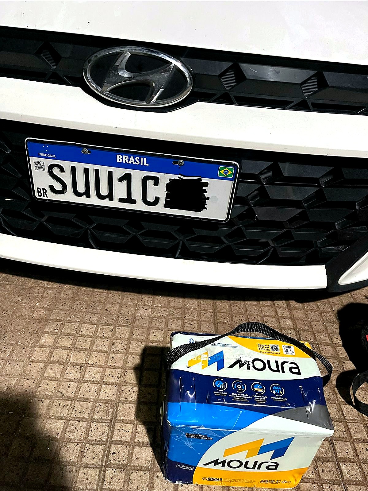 Bateria automotiva ao lado de veículo atendido pela Peterson Baterias
